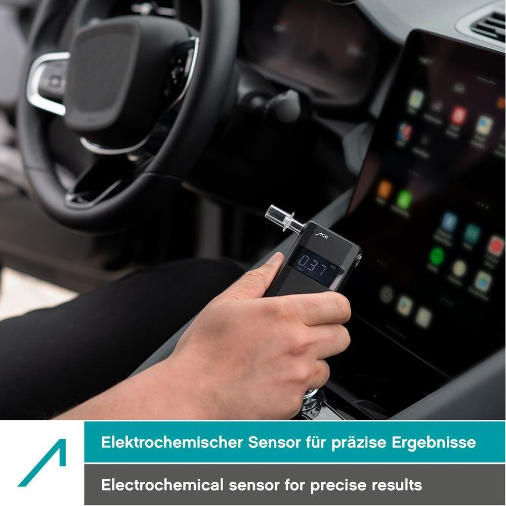 Person hält Atemalkoholtester im Auto, Anzeige zeigt 0,37. Armaturenbrett und Bildschirm sichtbar.
