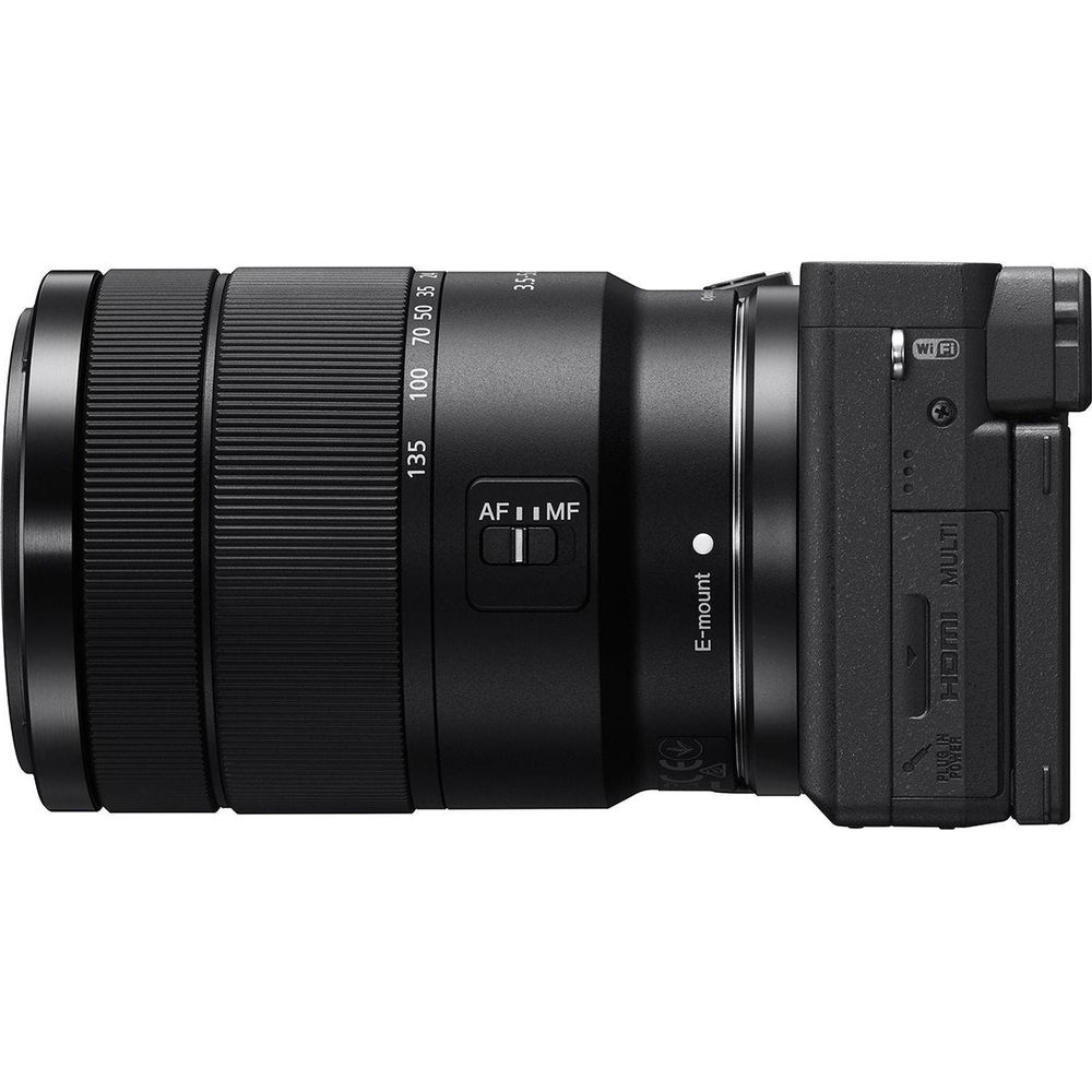 Fotocamera nera con obiettivo zoom, attacco E, interruttore AF/MF e porta HDMI.