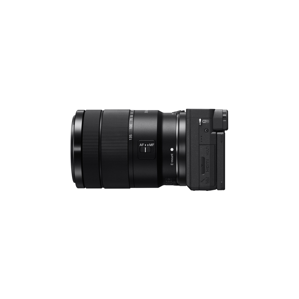 Una fotocamera nera con obiettivo su sfondo bianco.
