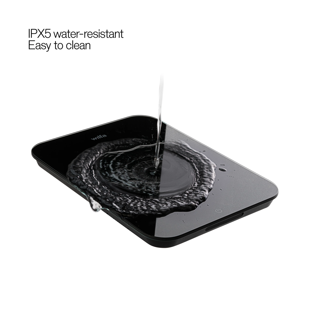 Schwarze digitale Waage mit spritzwassergeschütztem Design. Wasser fließt über die Oberfläche.