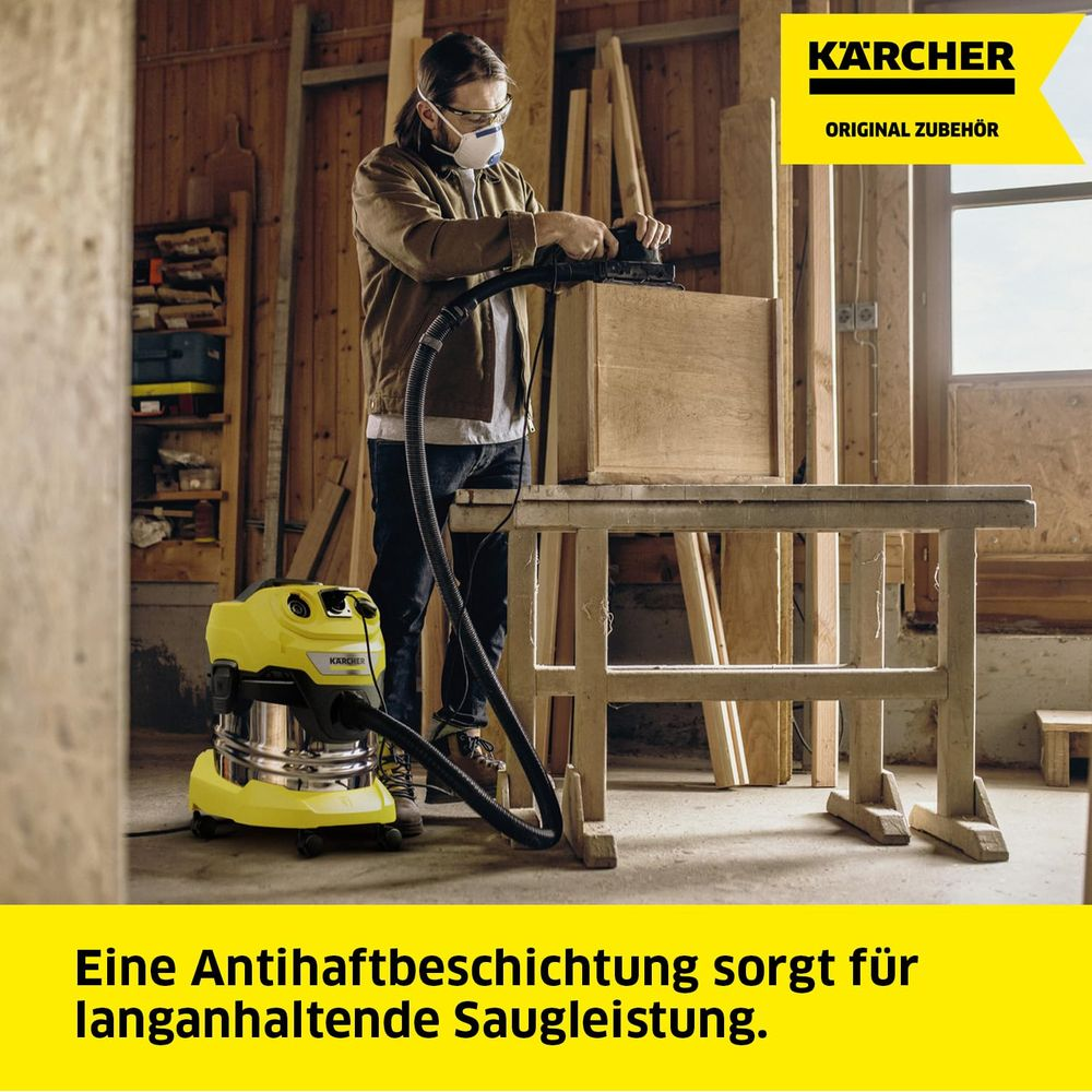 Mann schleift Holzkiste, gelber Kärcher Sauger daneben.