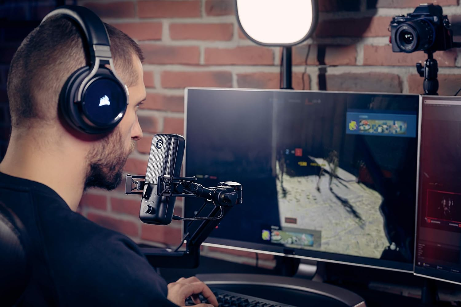 Un jugador con auriculares usa un micrófono en un escritorio con varios monitores.