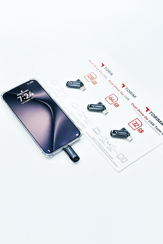 Takılı USB bellekli akıllı telefon, yanında diğer USB bellekler ve ambalaj.