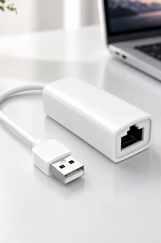 Arkada dizüstü bilgisayar bulunan beyaz USB'den Ethernet'e adaptör.