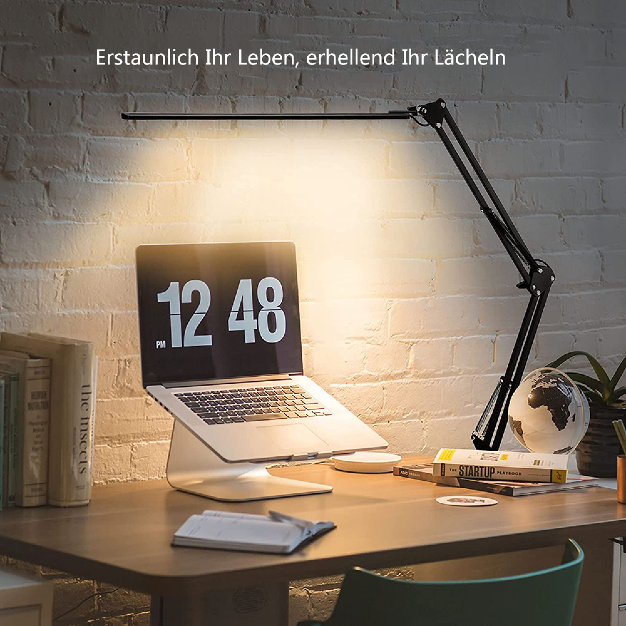 Ein Schreibtisch mit Laptop, Büchern, einer Lampe und einem Globus.