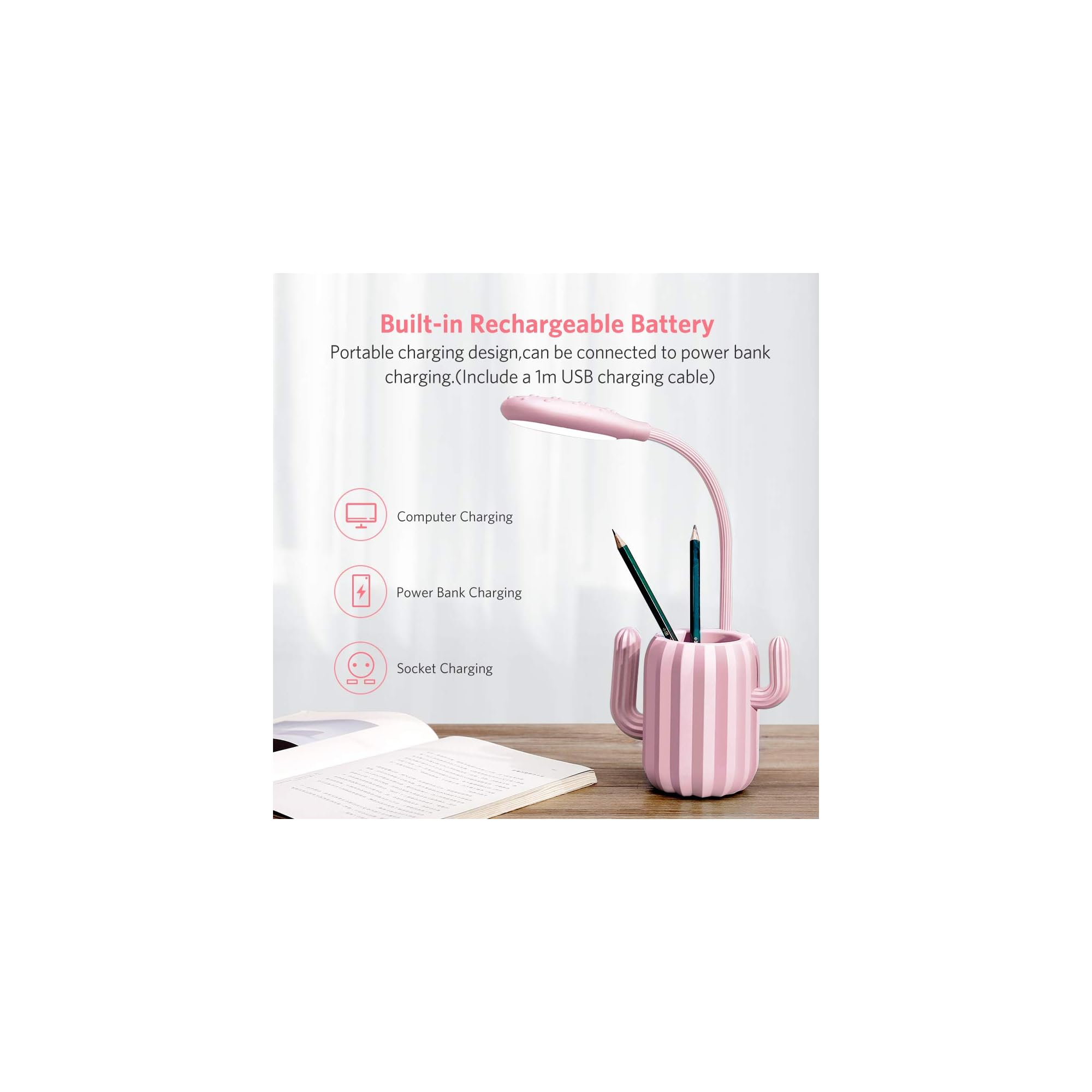 Ein pinker Kaktus-Stifthalter mit Lampe und Buch auf einem Holztisch.