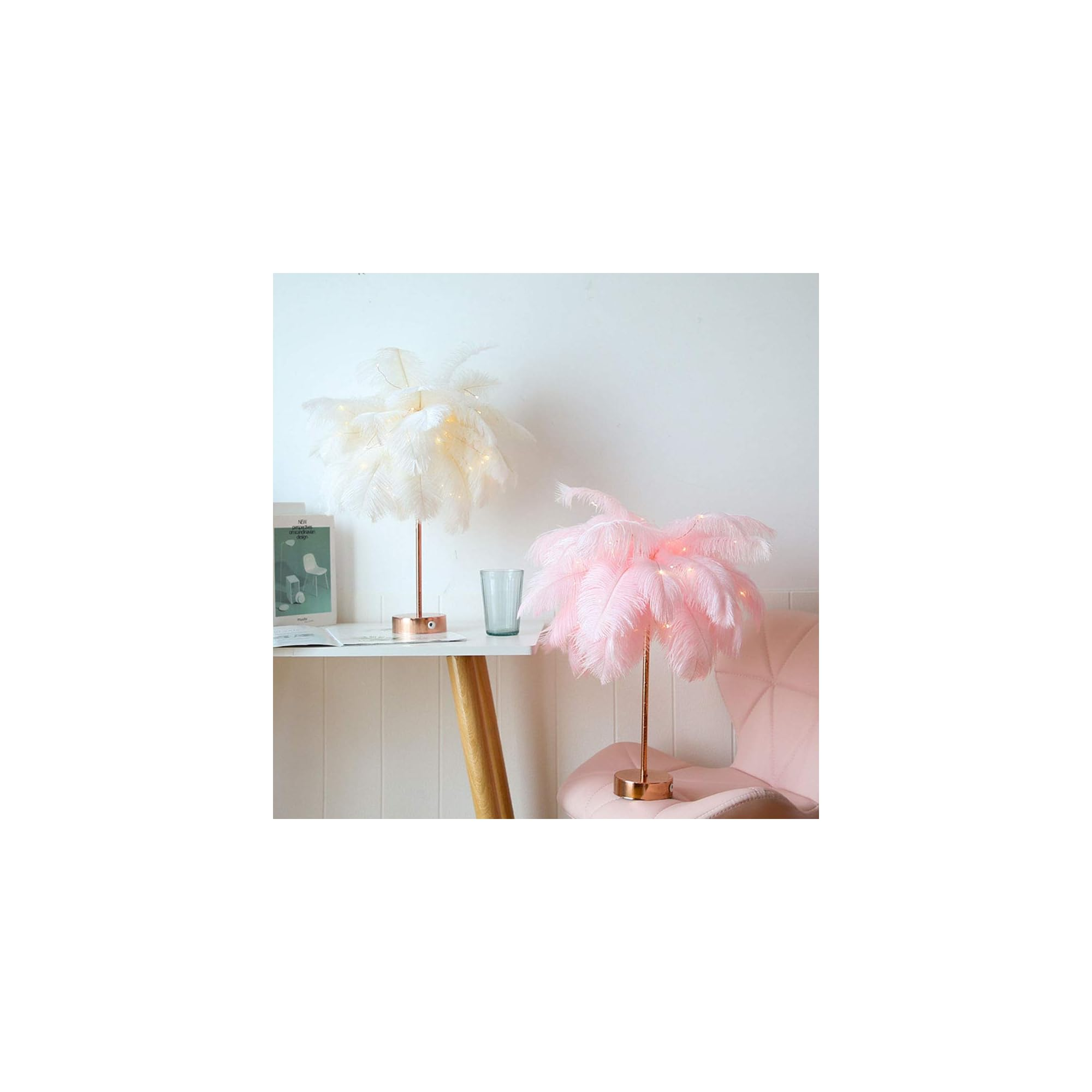 Zwei Federlampen, eine weiße und eine rosa, stehen auf einem Tisch neben einem Glas.