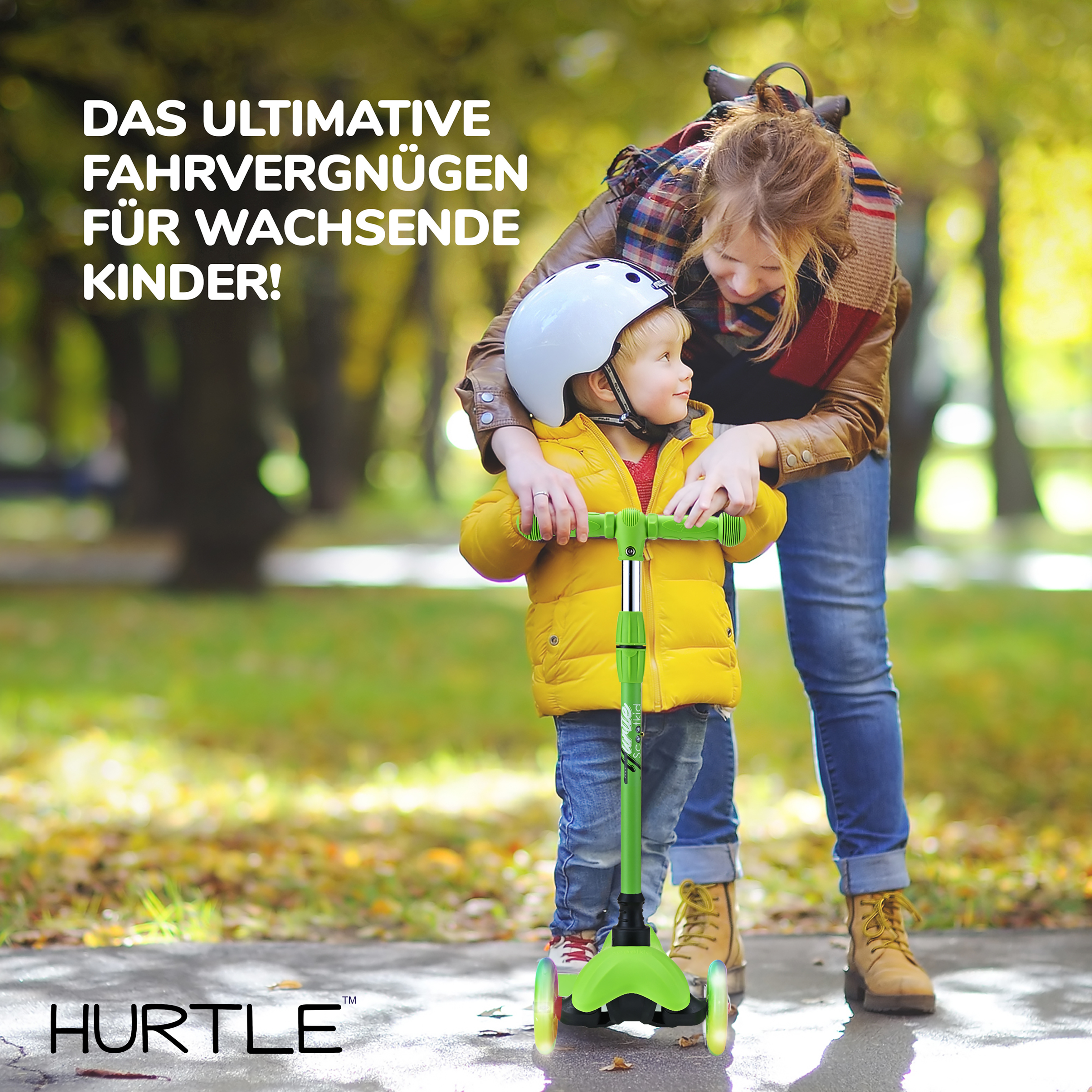 Mutter stützt Kind auf einem grünen Roller mit leuchtenden Rädern im Herbstpark.