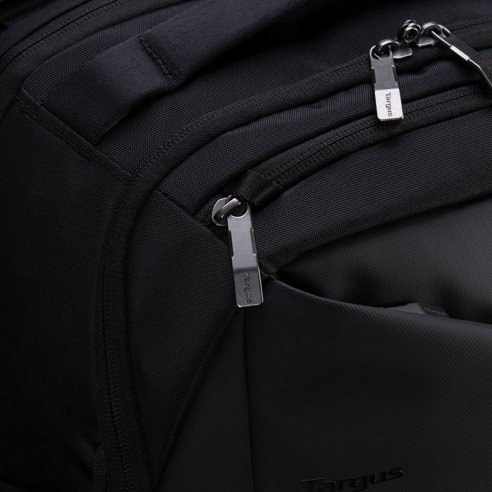 Nahaufnahme eines schwarzen Rucksacks mit silbernen Reißverschlüssen und dem Targus-Logo.