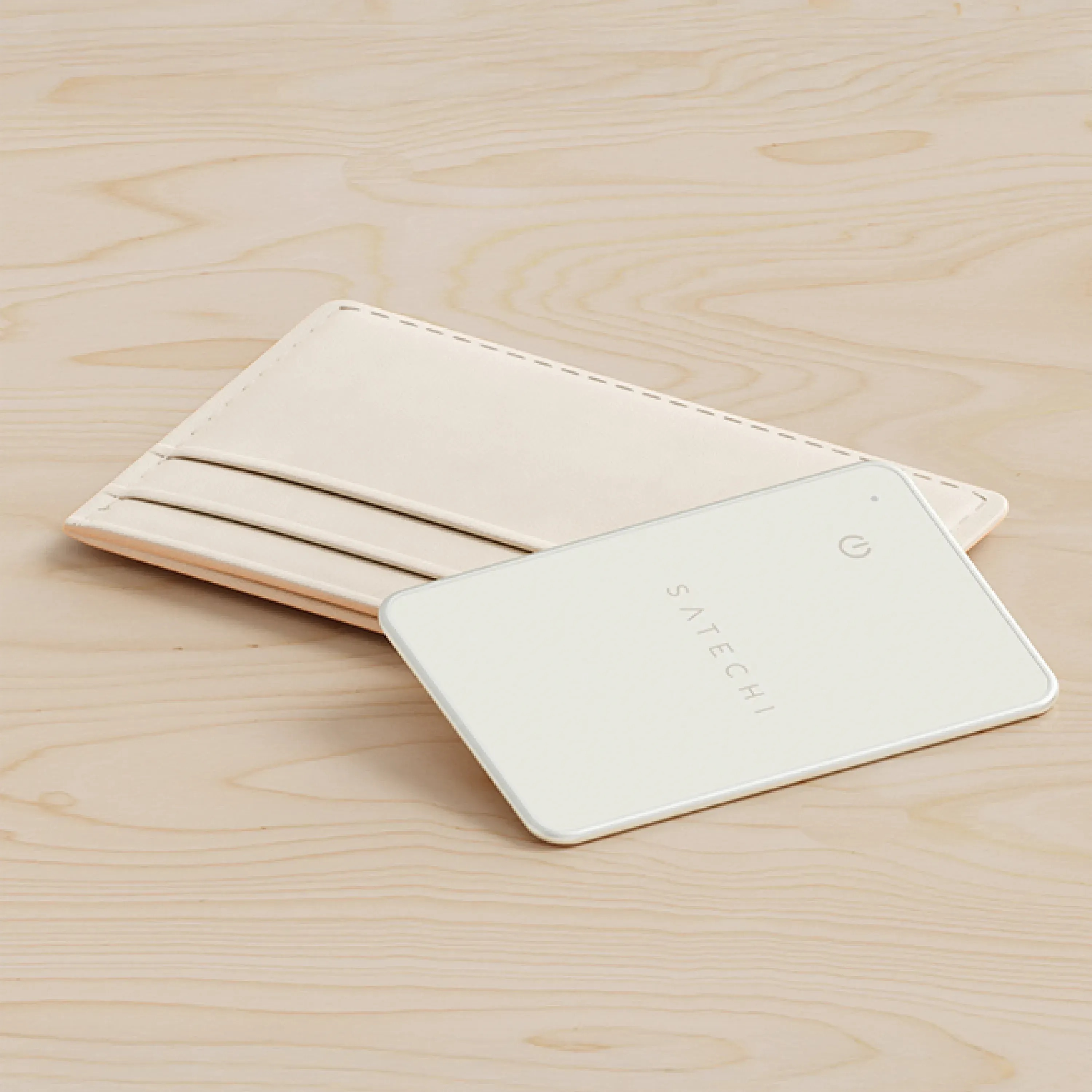 Jasnokremowy etui na karty i power bank na jasnej drewnianej powierzchni.