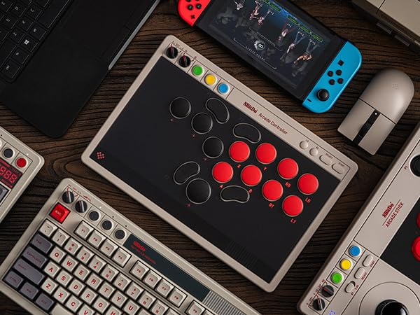 Akcesoria gamingowe na drewnie: kontrolery, klawiatura, Switch i mysz.