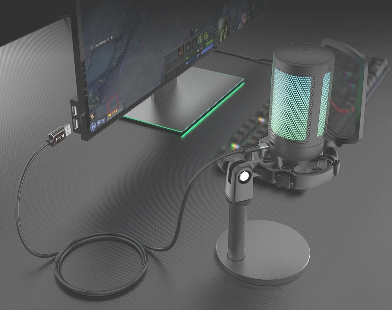 Mikrofon z podświetleniem RGB stoi na biurku obok monitora.
