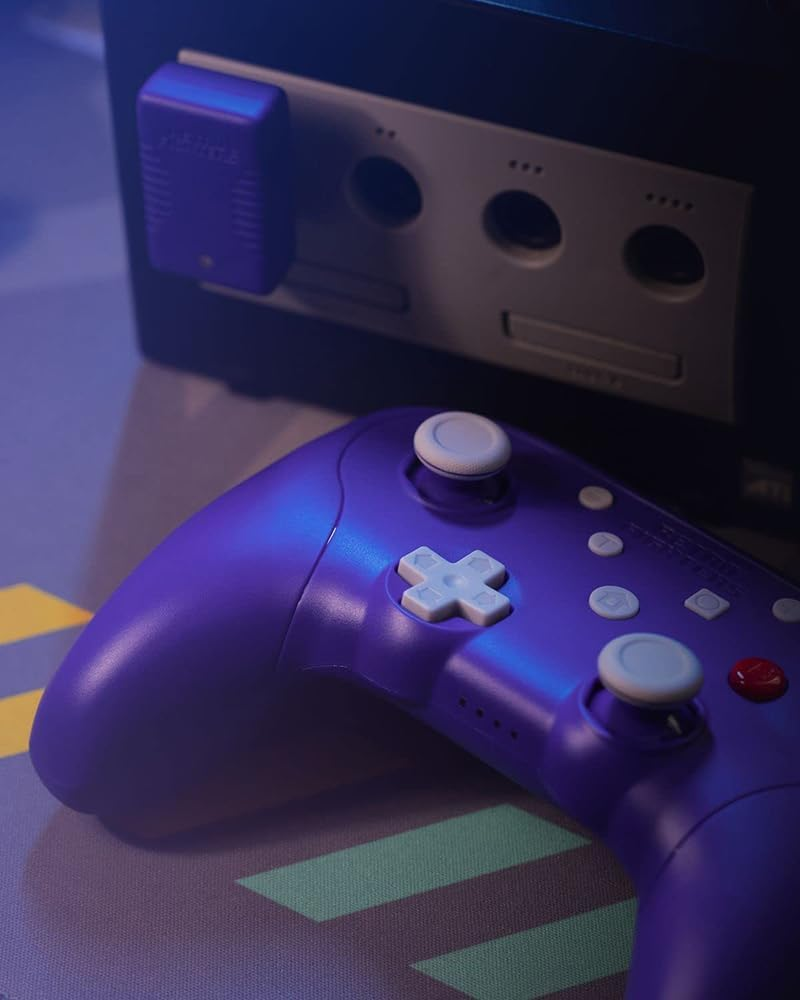 Fioletowy kontroler i konsola Gamecube z kartą pamięci. Zbliżenie.