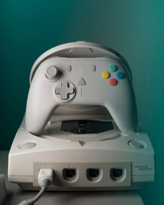 Un controller bianco poggia su una console di gioco bianca.