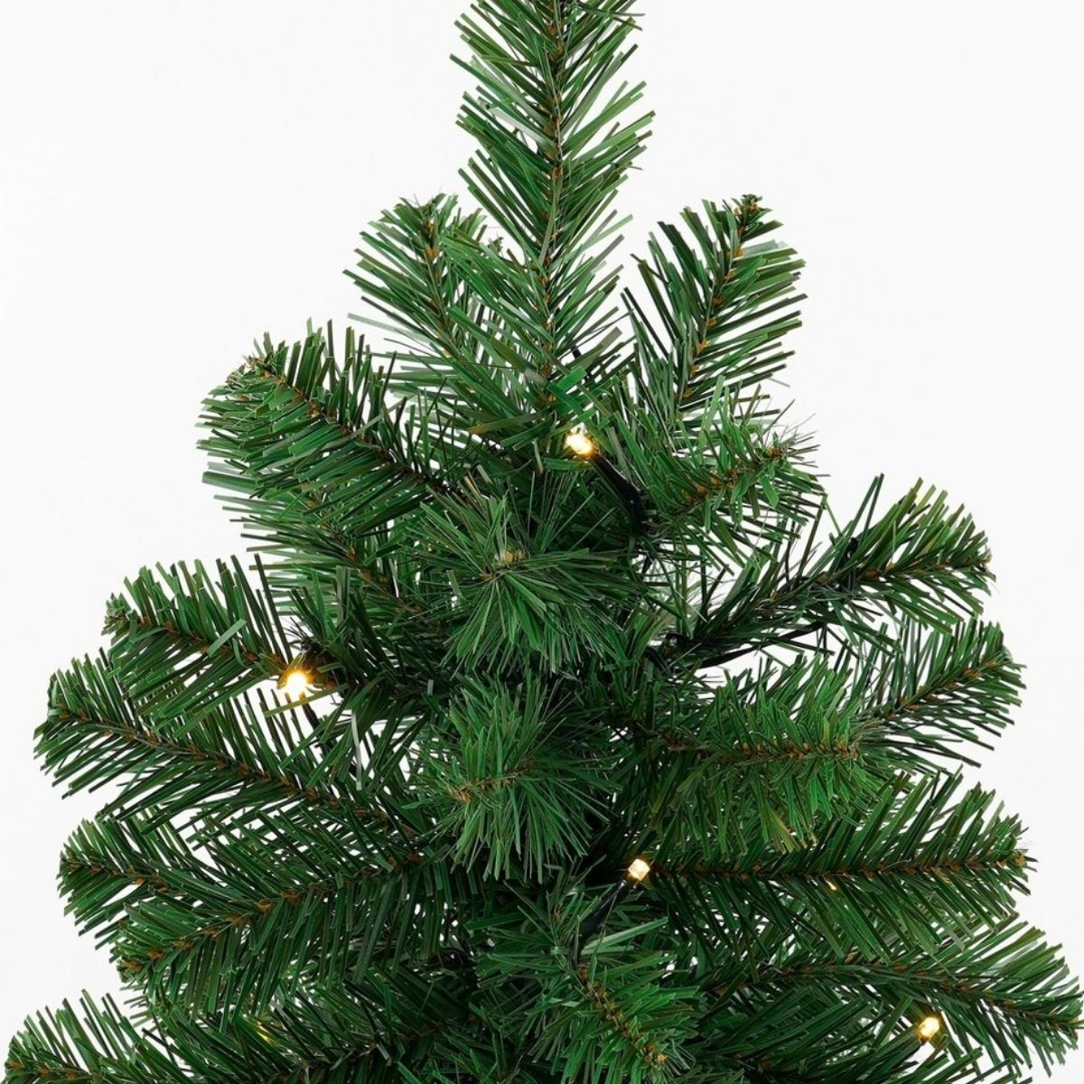 Close-up of an artificial Christmas tree with green needles and string lights.