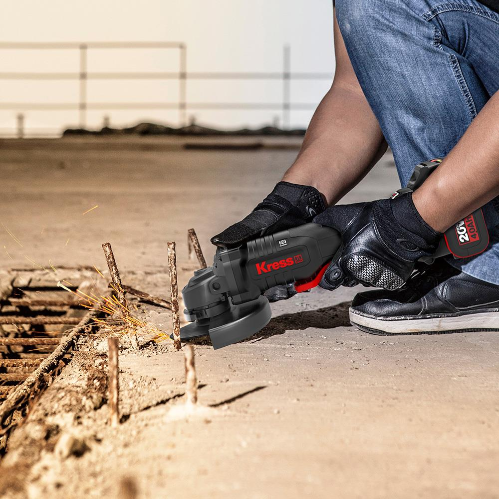 Bir kişi beton yüzeydeki metal çubukları taşlama makinesiyle zımparalıyor.