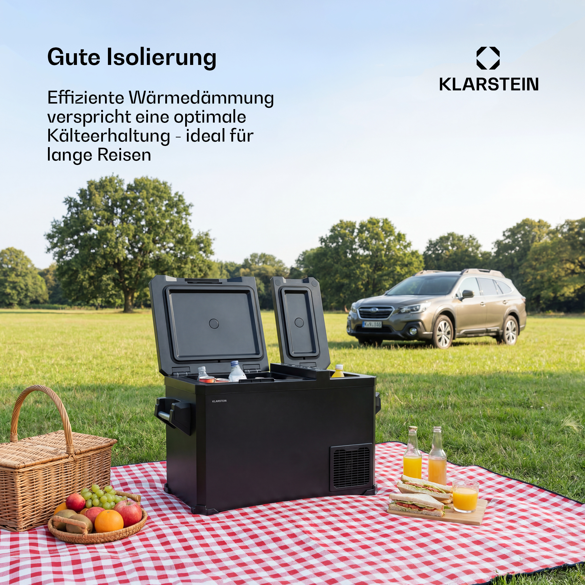 Ein schwarzer Kühlbox steht auf einer Decke im Freien, daneben ein Picknickkorb und Sandwiches.