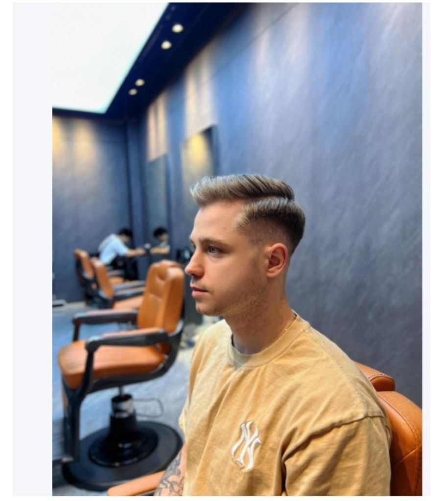 Ein Mann mit neuem Haarschnitt sitzt im Friseursalon.