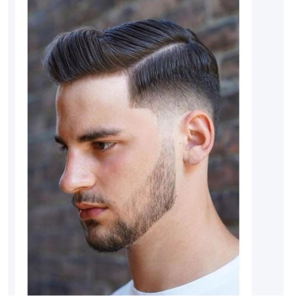 Ein Mann mit einem modernen Haarschnitt mit Seitenscheitel und einem gepflegten Bart.