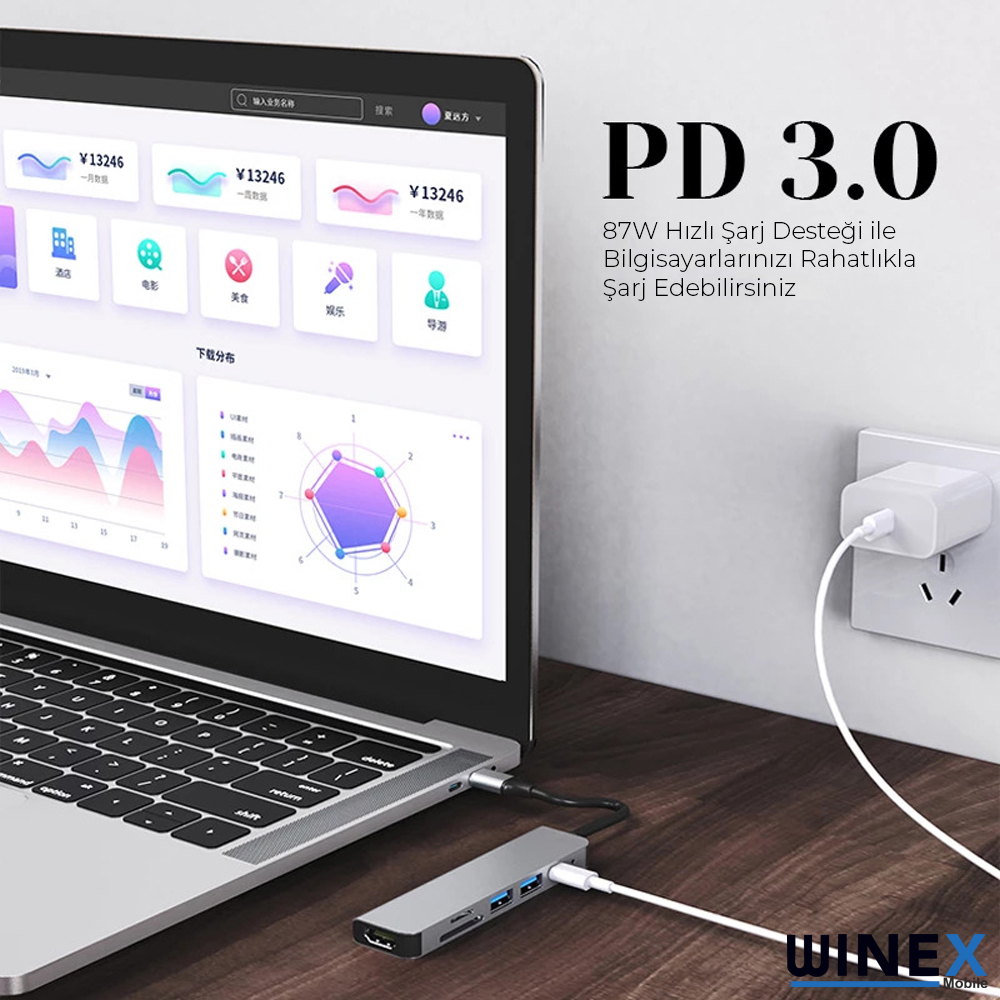 Bir dizüstü bilgisayar USB-C hub'ına ve güç adaptörüne bağlı.