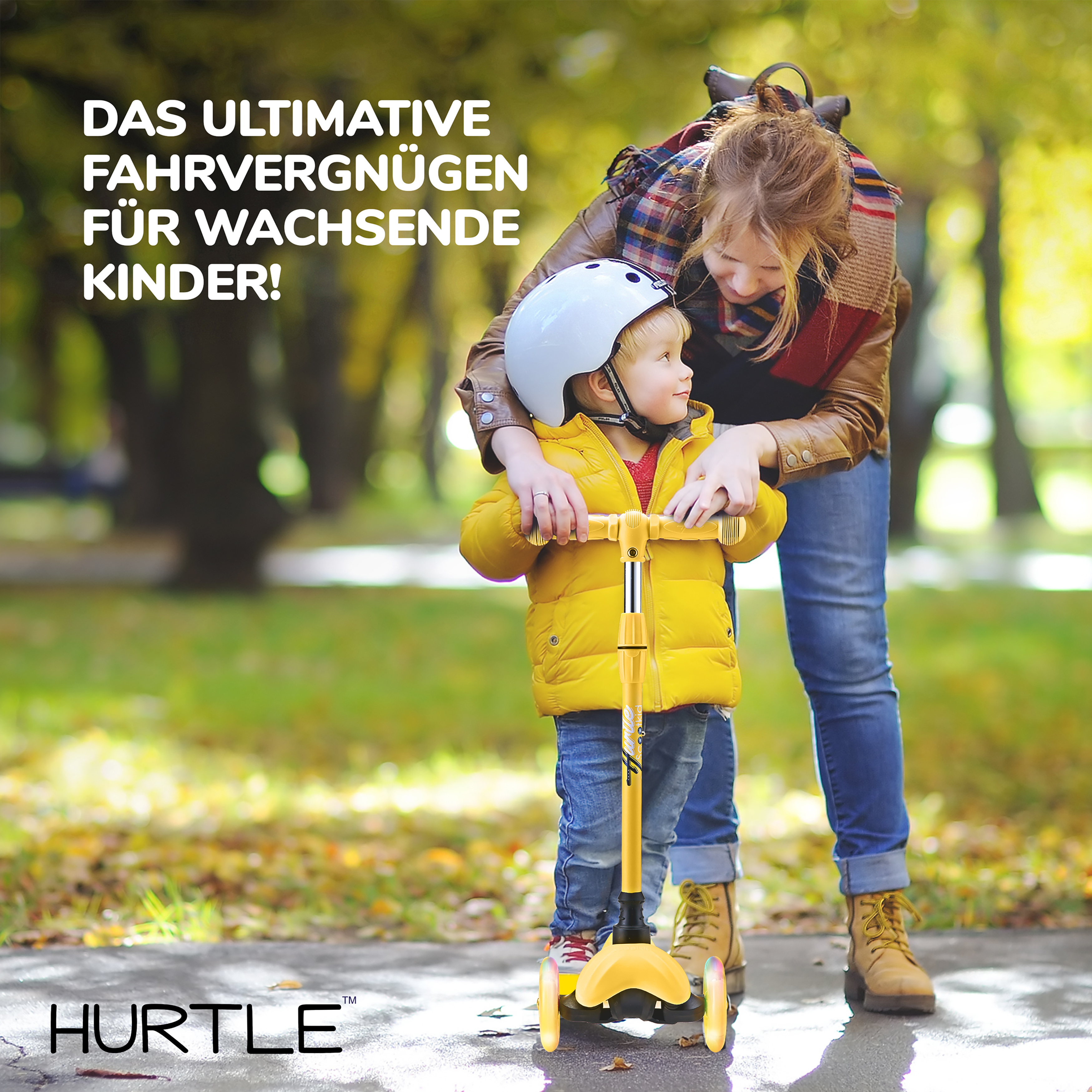 Frau mit Kind auf einem Roller im Herbstpark mit Laub.