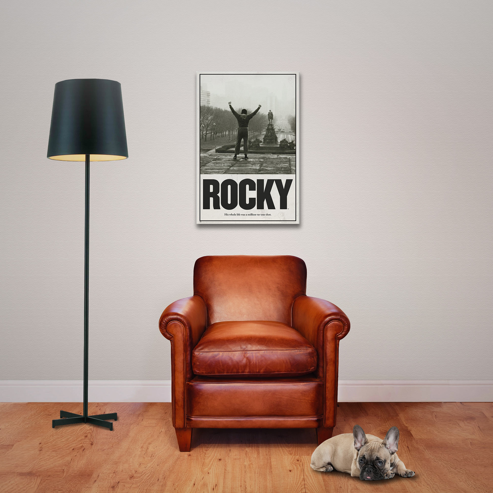 Ein brauner Ledersessel mit einem Hund davor, links eine Stehlampe, rechts ein Rocky-Poster.