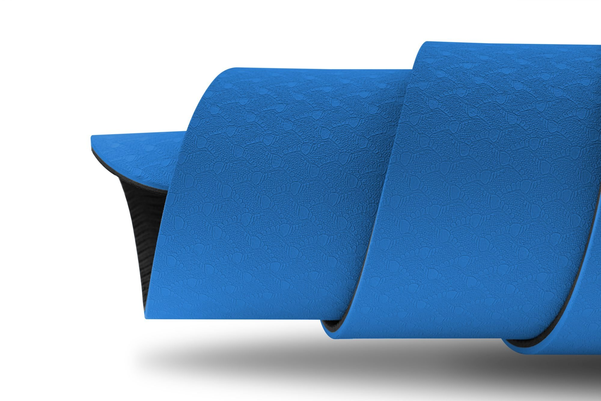 Eine blaue Yogamatte ist aufgerollt und zeigt ihre strukturierte Oberfläche. Die Matte hat eine schwarze Unterseite.