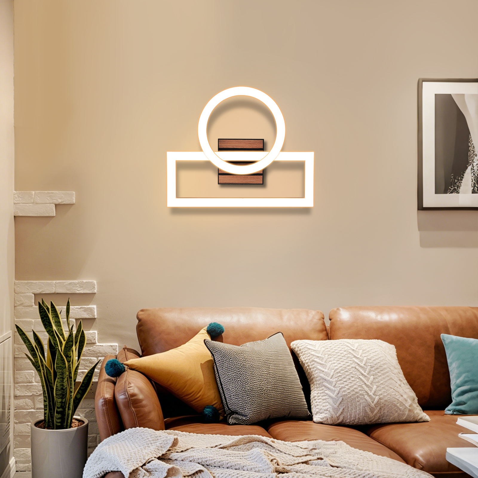 Ein braunes Ledersofa mit Kissen und einer modernen Wandleuchte an einer beigen Wand.
