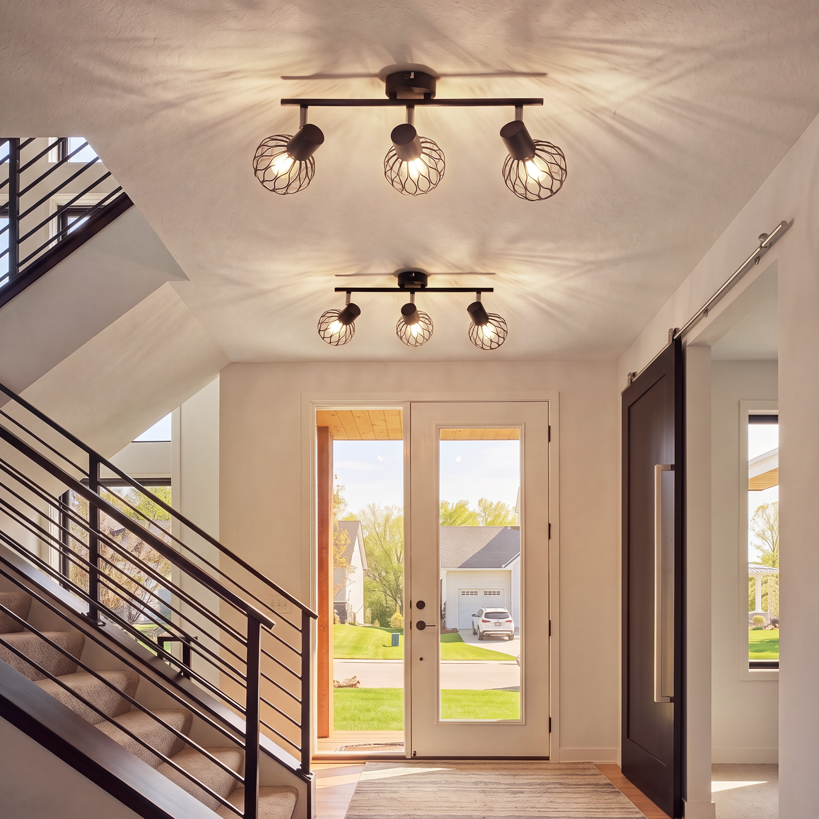 Pasillo con escaleras, puerta corredera, luces de techo, vista al exterior.
