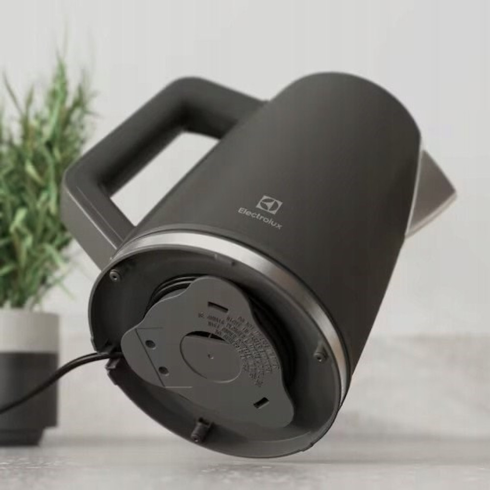 Ciemnoszary czajnik Electrolux na blacie z widocznym schowkiem na kabel.