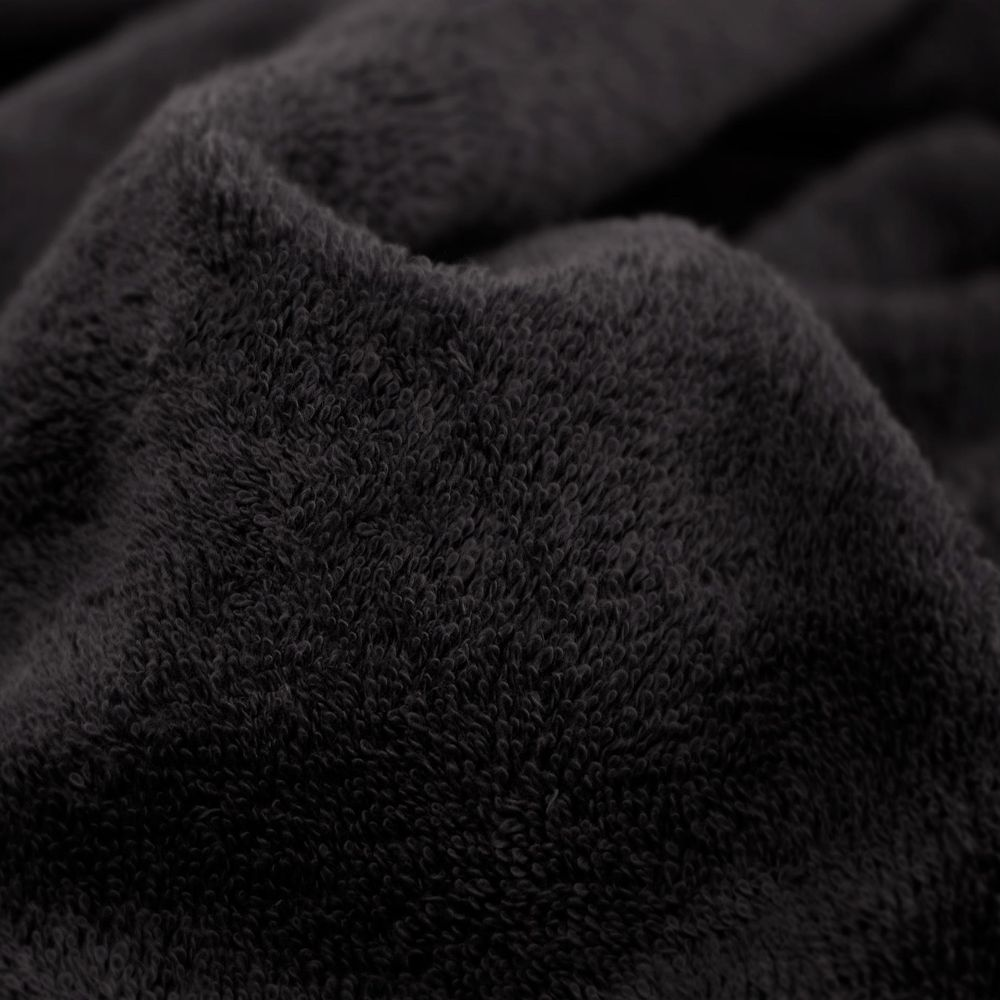 Nahaufnahme eines dunkelgrauen flauschigen Stoffes, zeigt Textur und Falten.