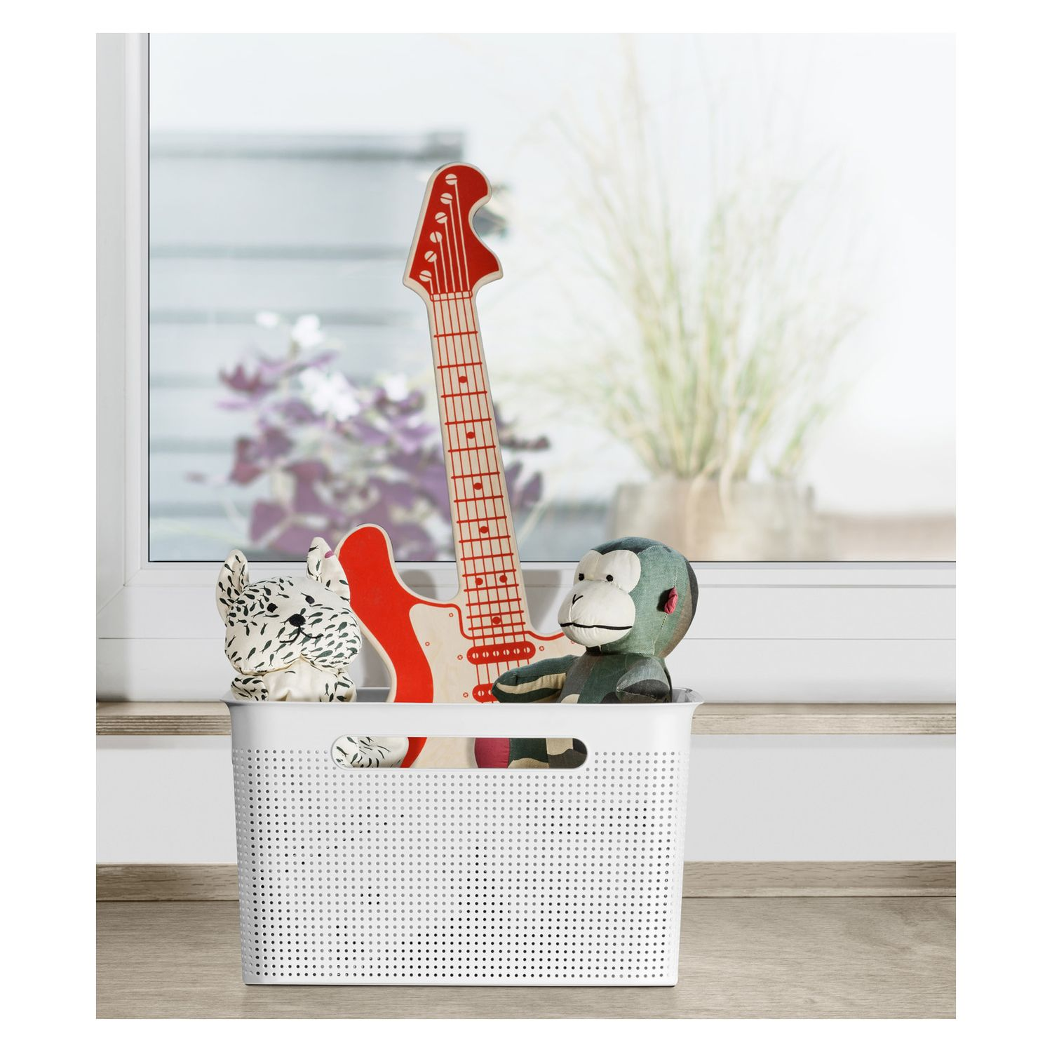 Biały koszyk z zabawkami: gitara, małpa i kot.