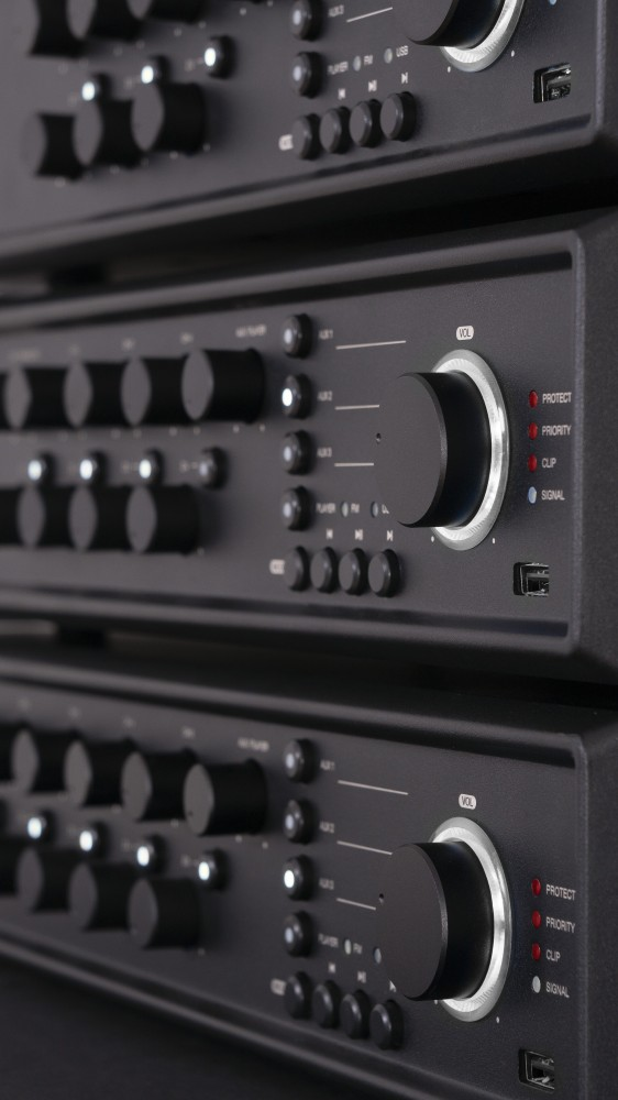 Ułożone czarne urządzenia audio z gałkami i światłami.