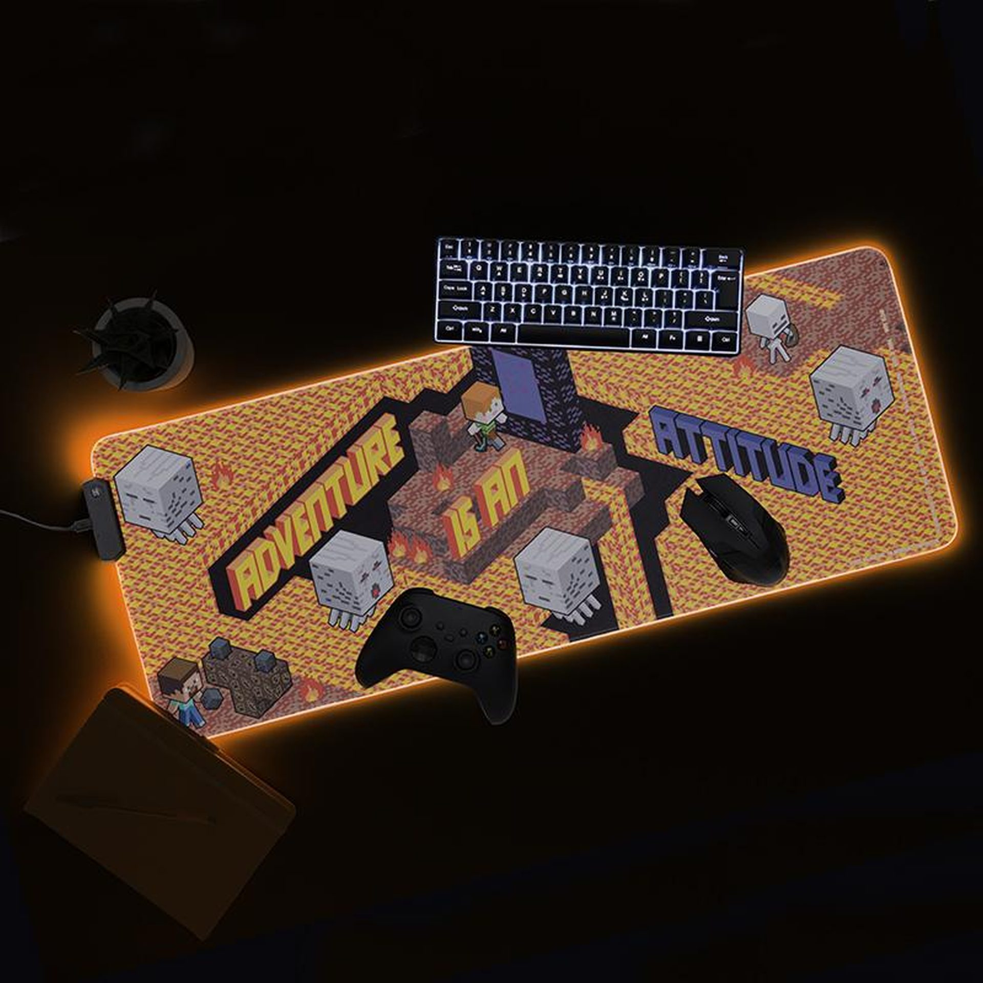 Podkładka pod mysz z motywem Minecraft z pomarańczowym oświetleniem LED, przedstawiająca postacie, tekst, klawiaturę, mysz i kontroler.
