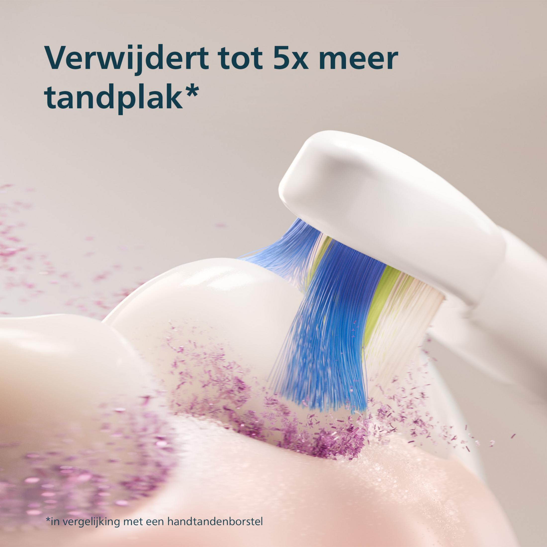 Spazzolino elettrico pulisce i denti con setole blu e particelle viola.