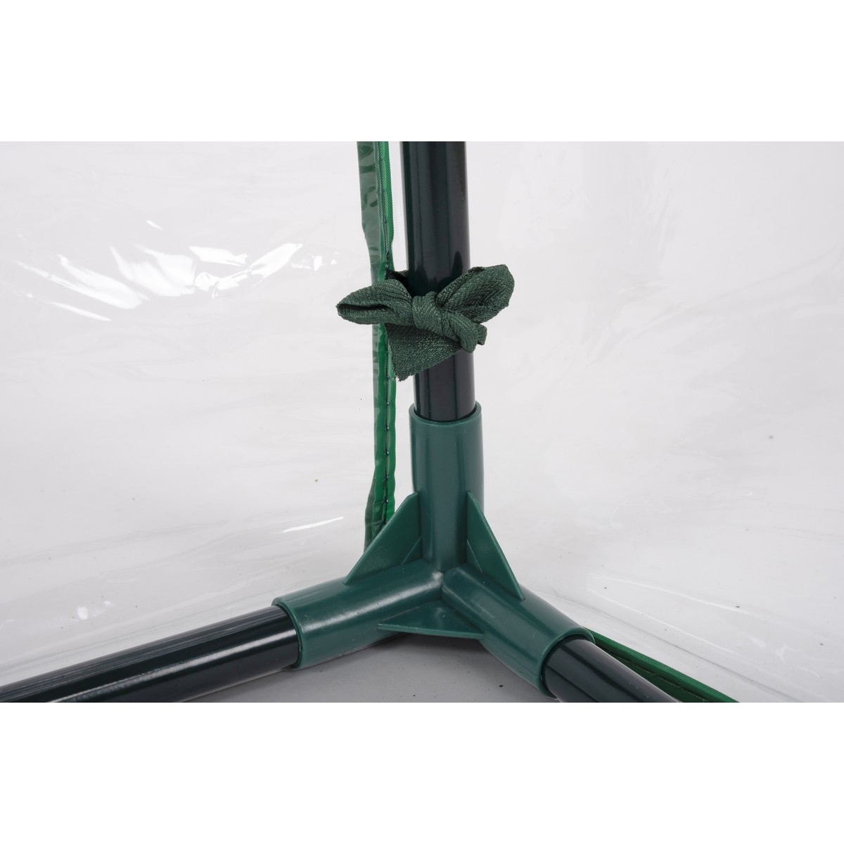 Green corner connector with black tubes and cord tied to a pole.