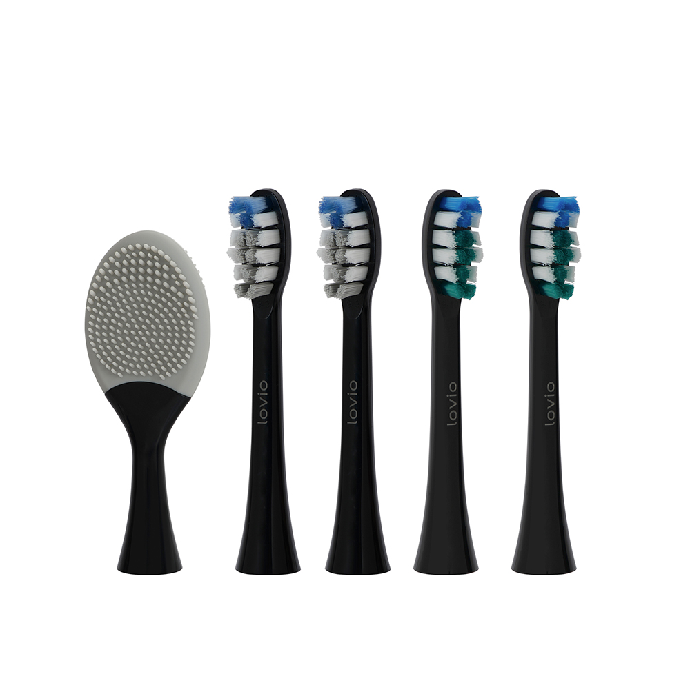 Una spazzola viso in silicone grigio e quattro testine di spazzolino nero con setole blu e verdi.