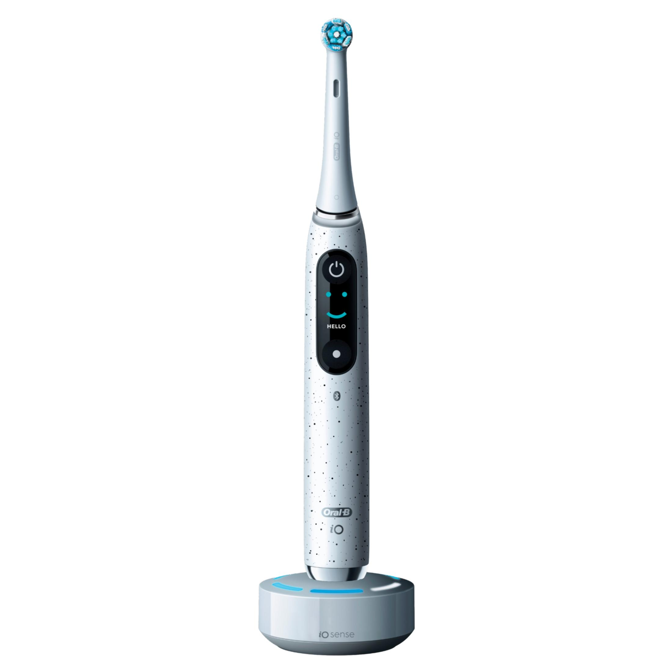 Spazzolino elettrico Oral-B bianco con setole blu su base di ricarica grigia.