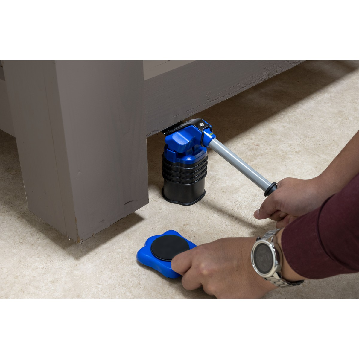 Un sollevatore blu solleva un mobile mentre una mano tiene uno scivolo blu.