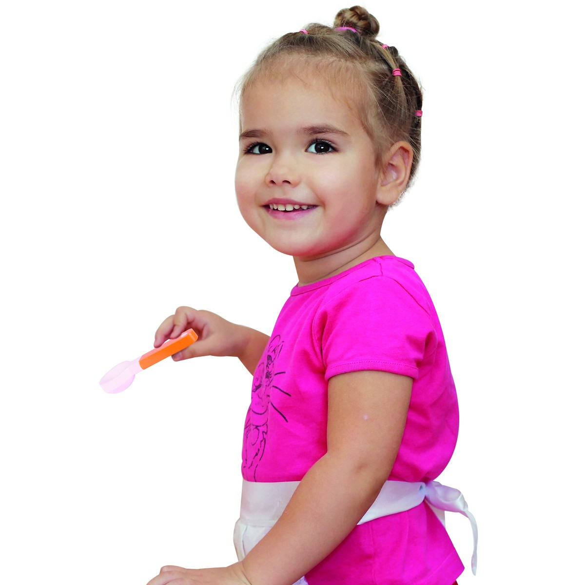 A little girl with buns and a pink shirt holds a spoon.