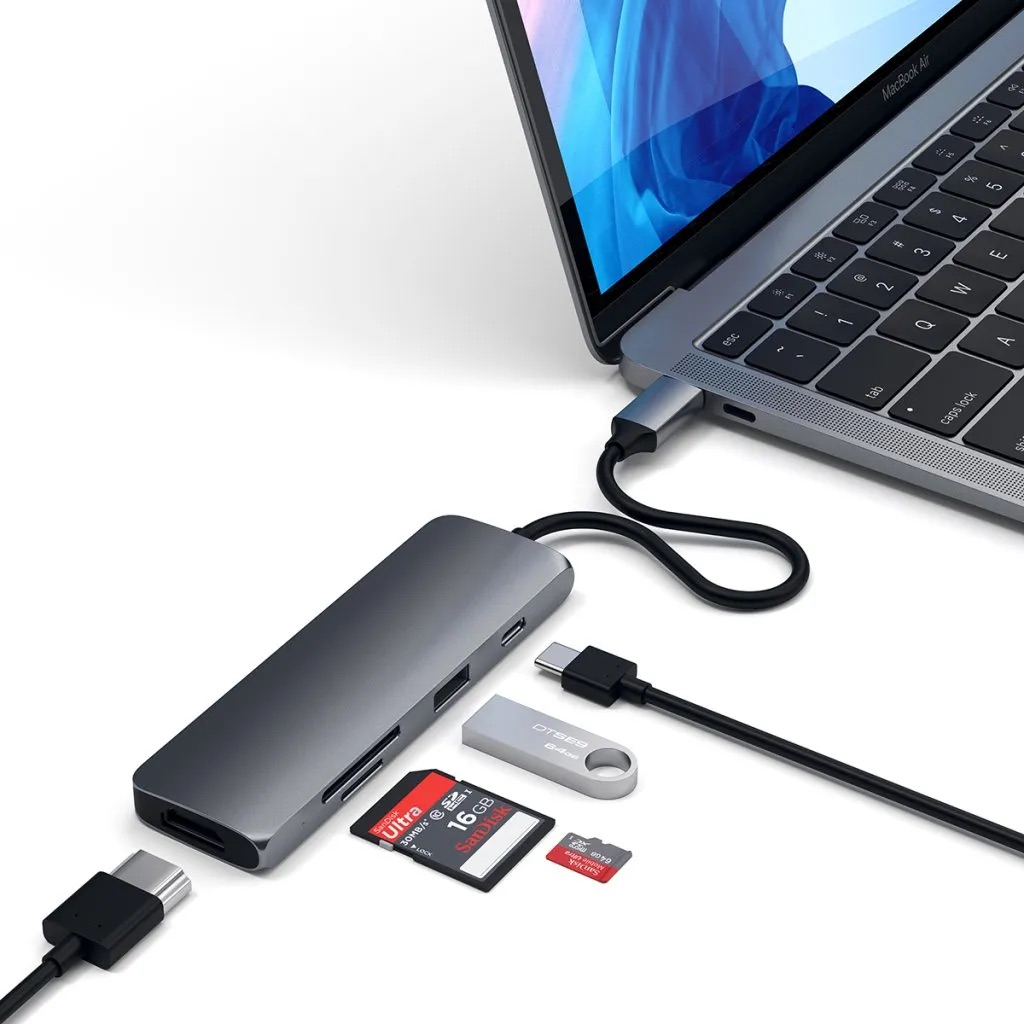 Koncentrator USB-C z kartami pamięci i pendrivem jest podłączony do laptopa.