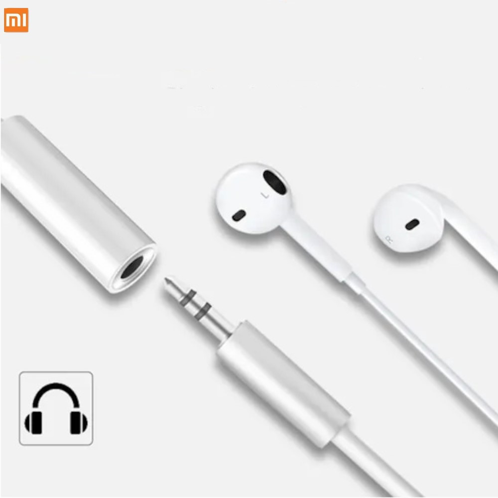 Beyaz kulaklıklar ve açık arka planda 3,5 mm jak adaptörü.