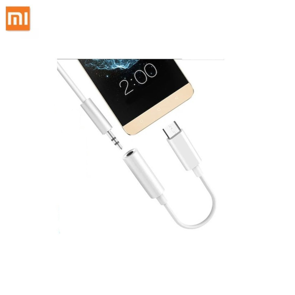 Akıllı telefonla beyaz bir USB-C - 3,5 mm adaptör. Adaptör bağlıdır.