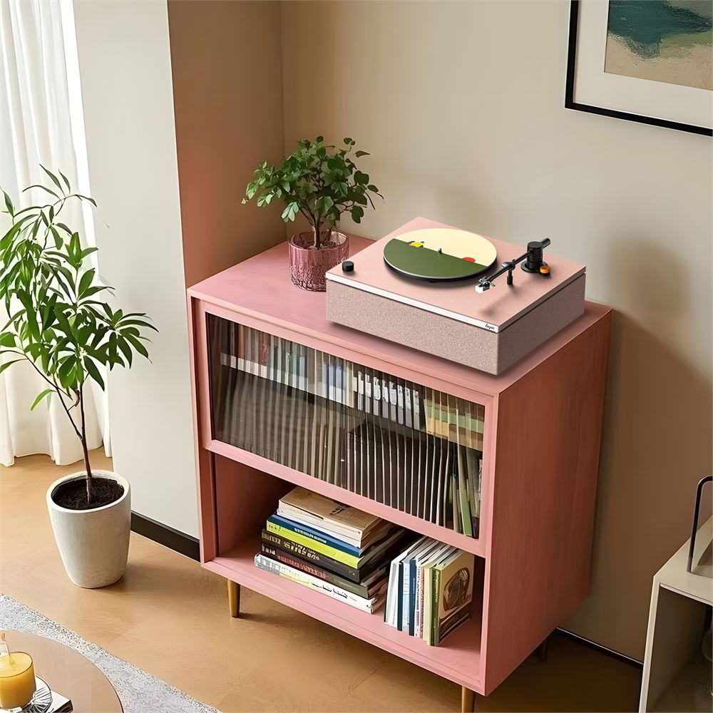 Pembe bir pikap, kitaplar ve bitkilerle dolu pembe bir dolabın üzerinde duruyor.