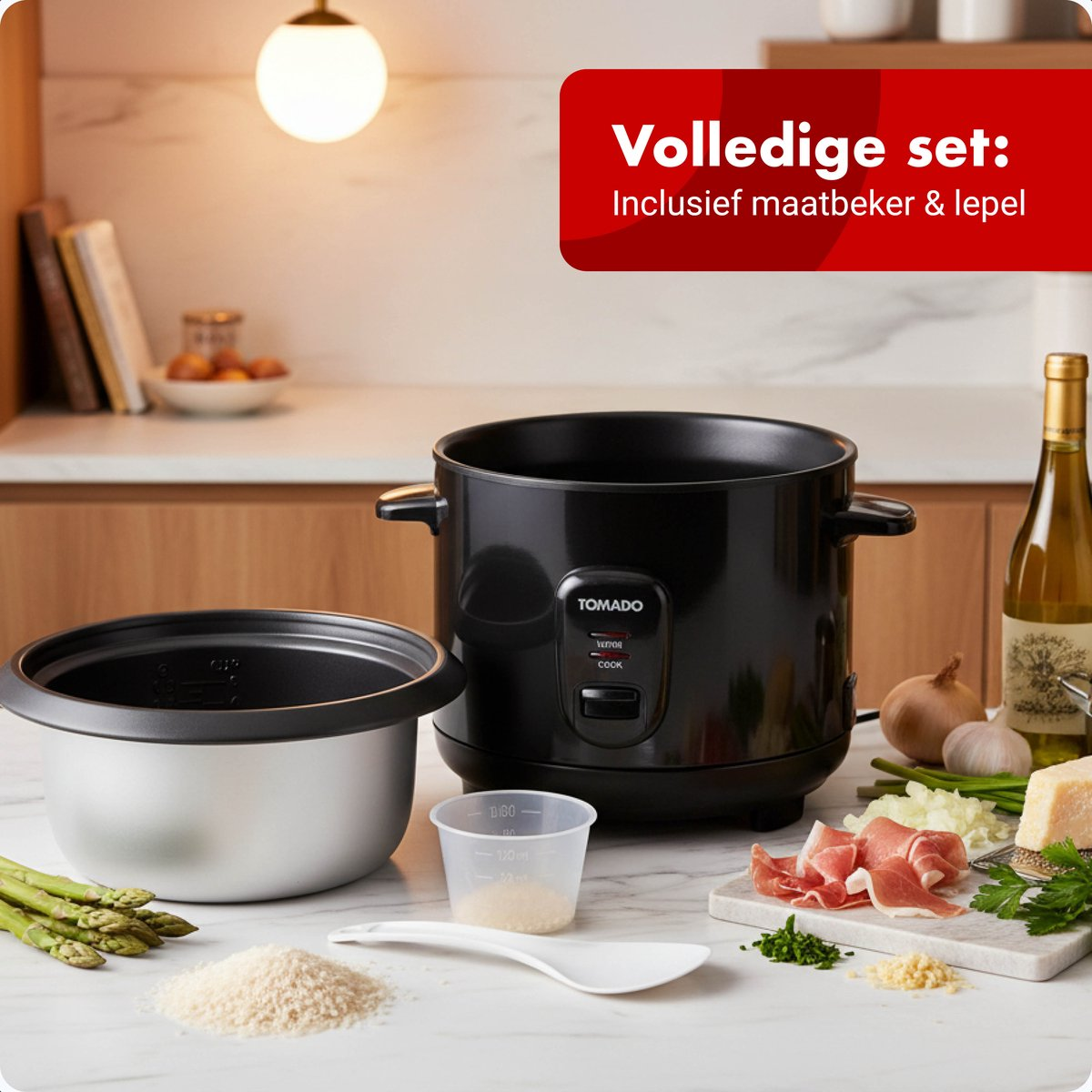 A black rice cooker with accessories, beside it a bowl, rice, and asparagus.