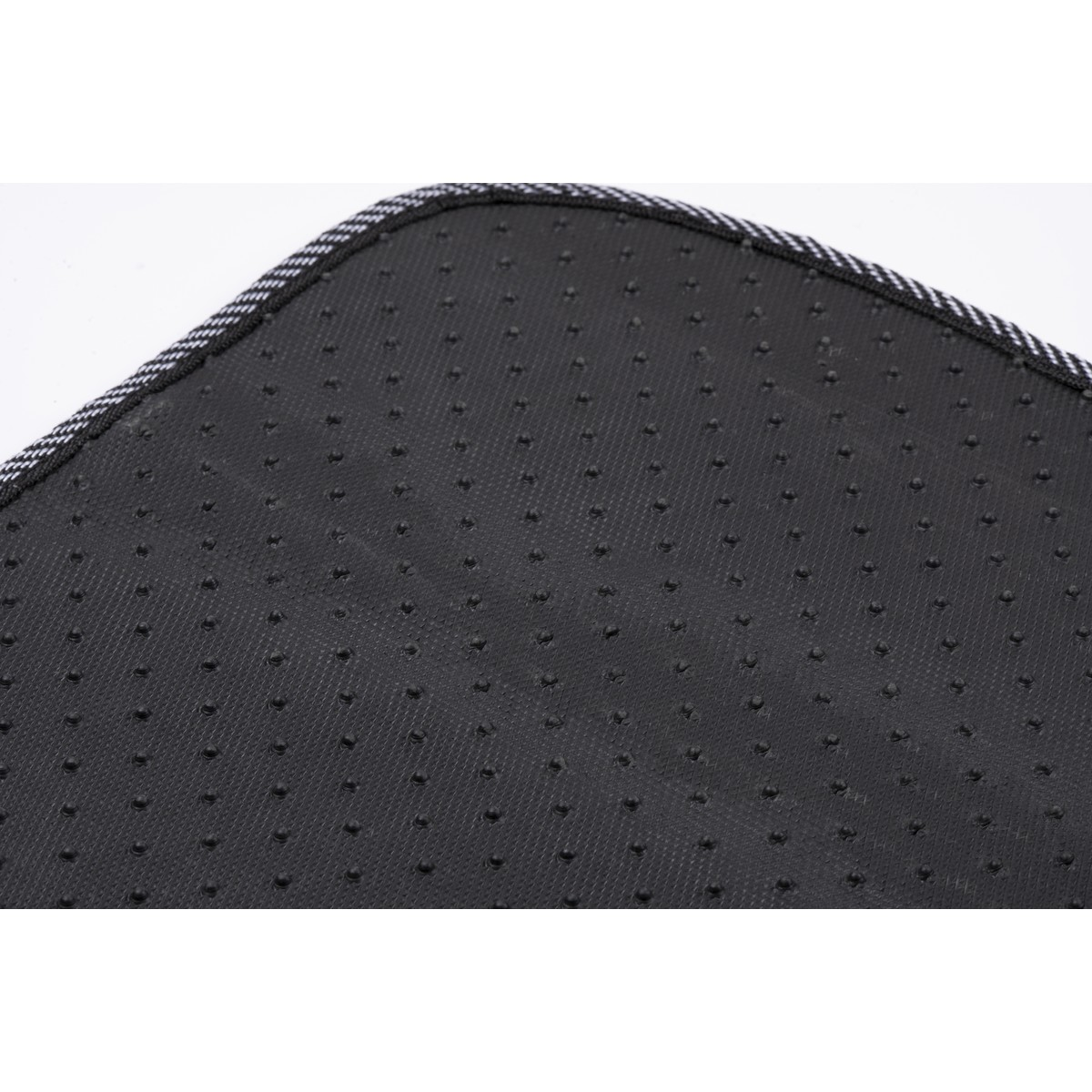 Back of a black carpet with dots and a striped edge.