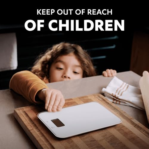 A child reaches for a kitchen scale on a wooden board.