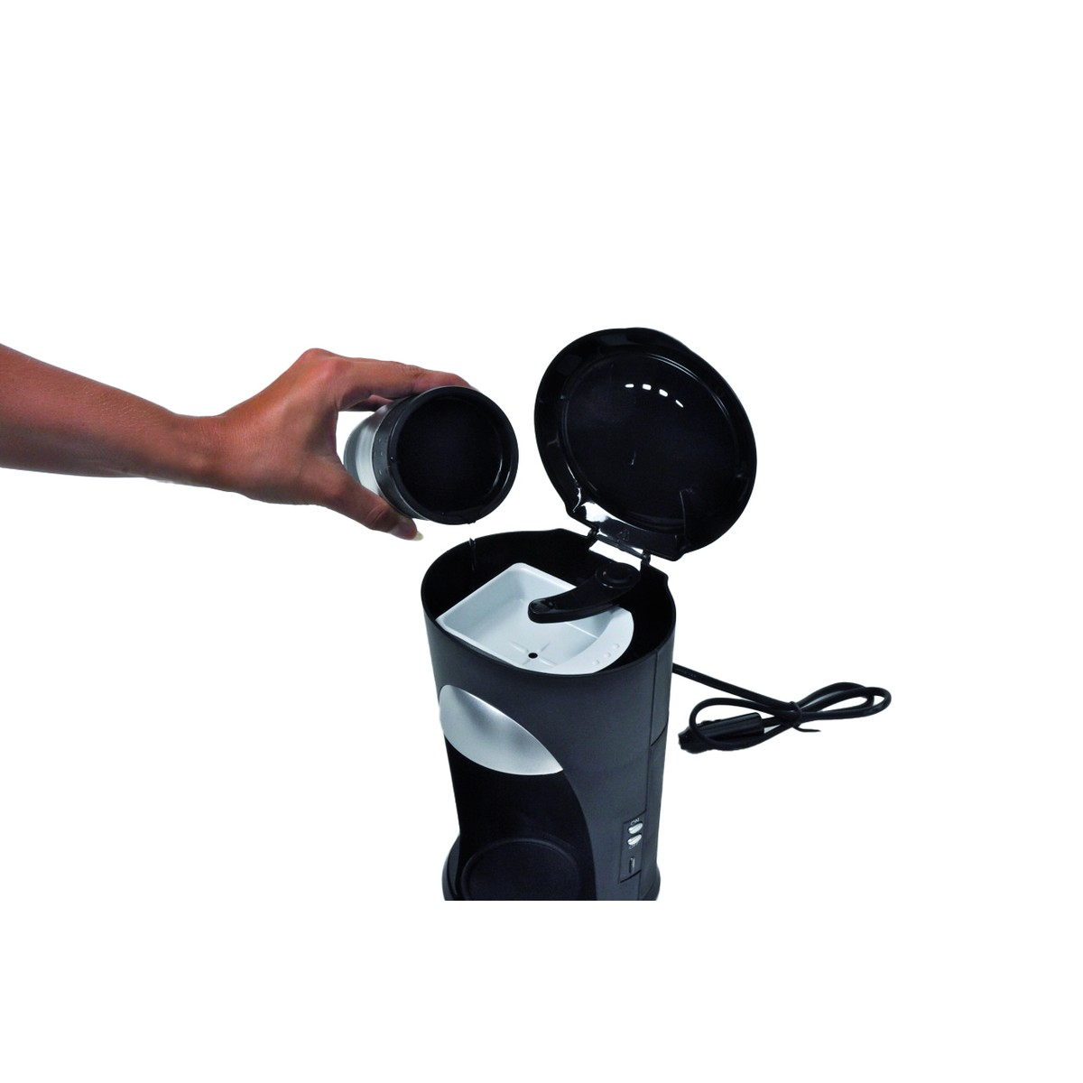 A hand holds a filter cup over a coffee maker with its lid open.