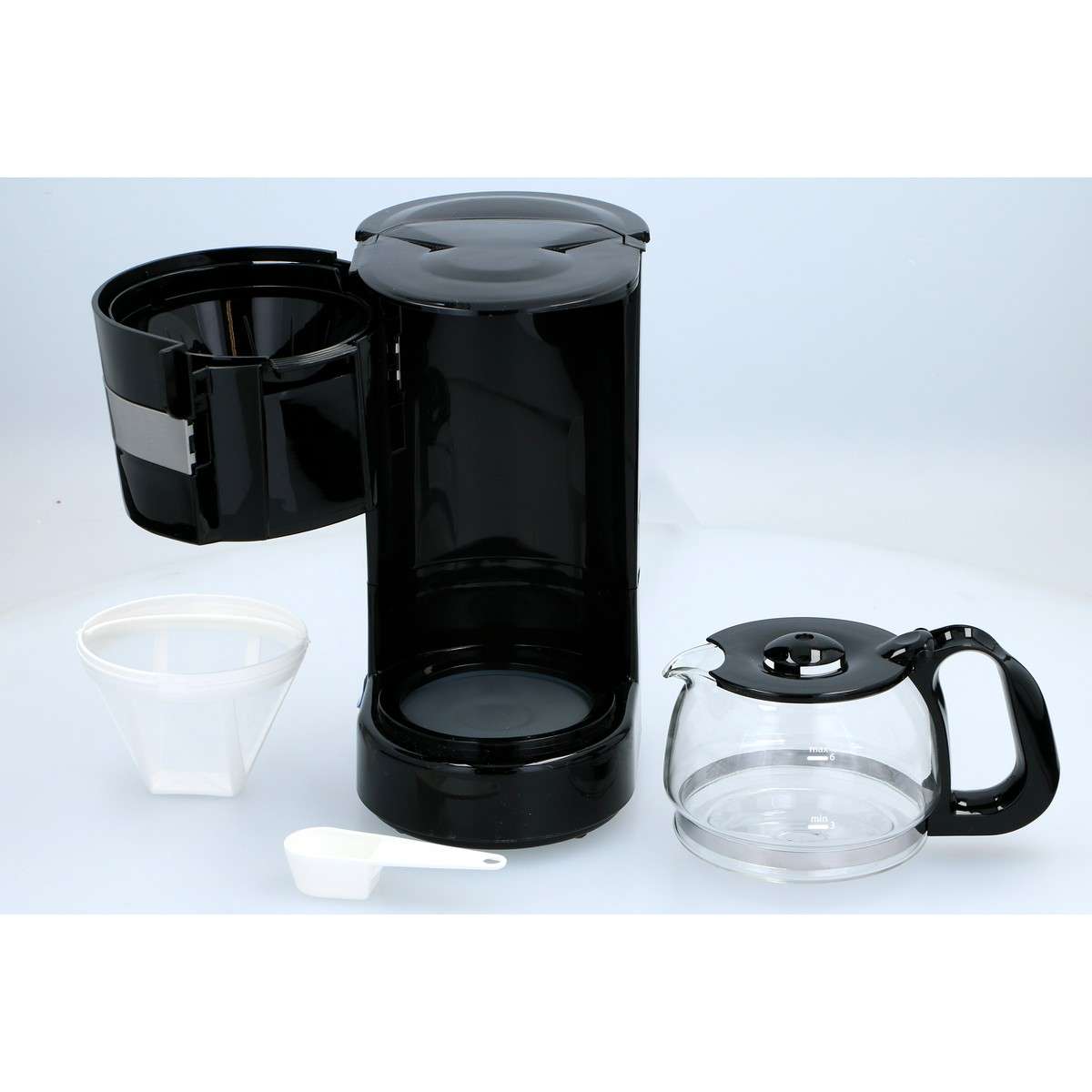 Black coffee maker with glass carafe, filter holder, insert, and scoop.