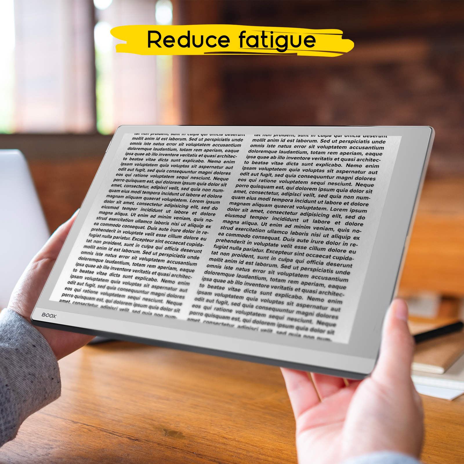 Mani che tengono un e-reader con testo. Barra gialla dice "Reduce fatigue".